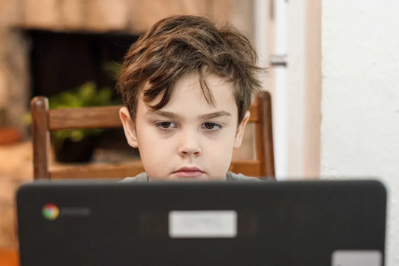 A child attending an online class on a laptop at home