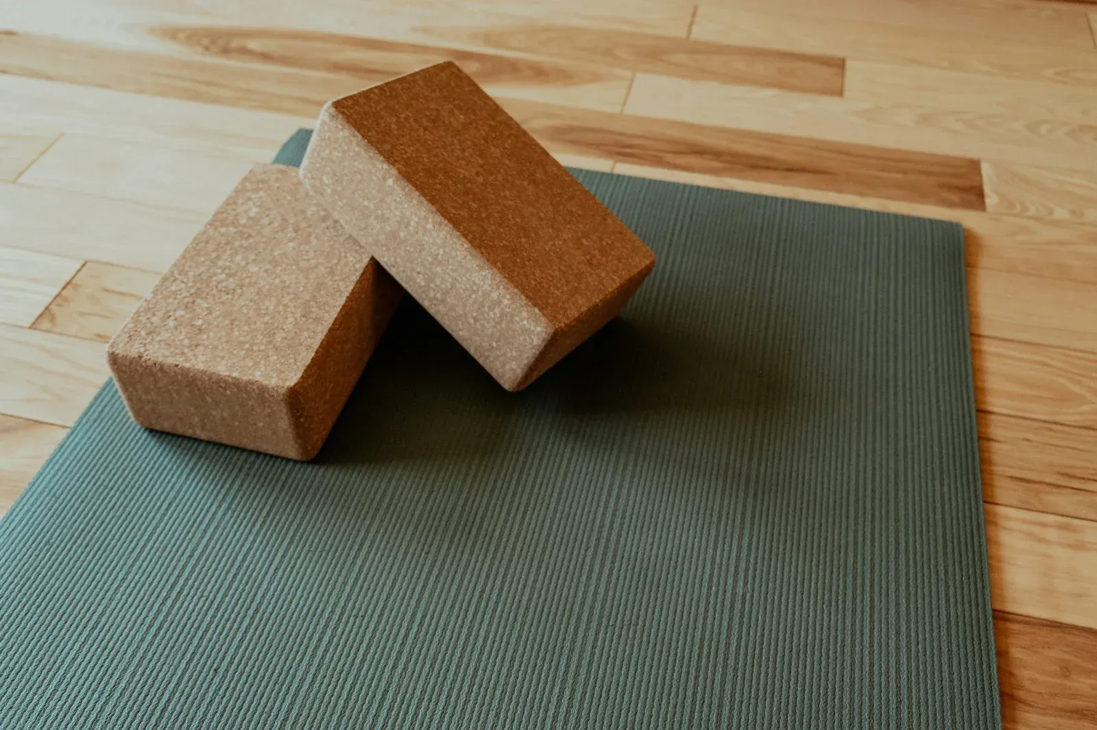 A yoga mat with two cork blocks laid out for a session