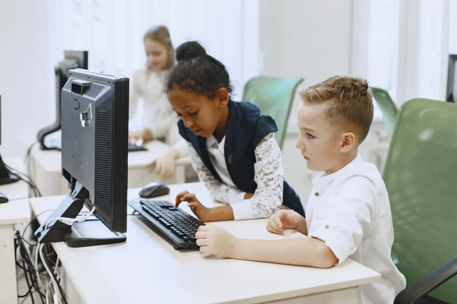 Children working together on computers in a classroom