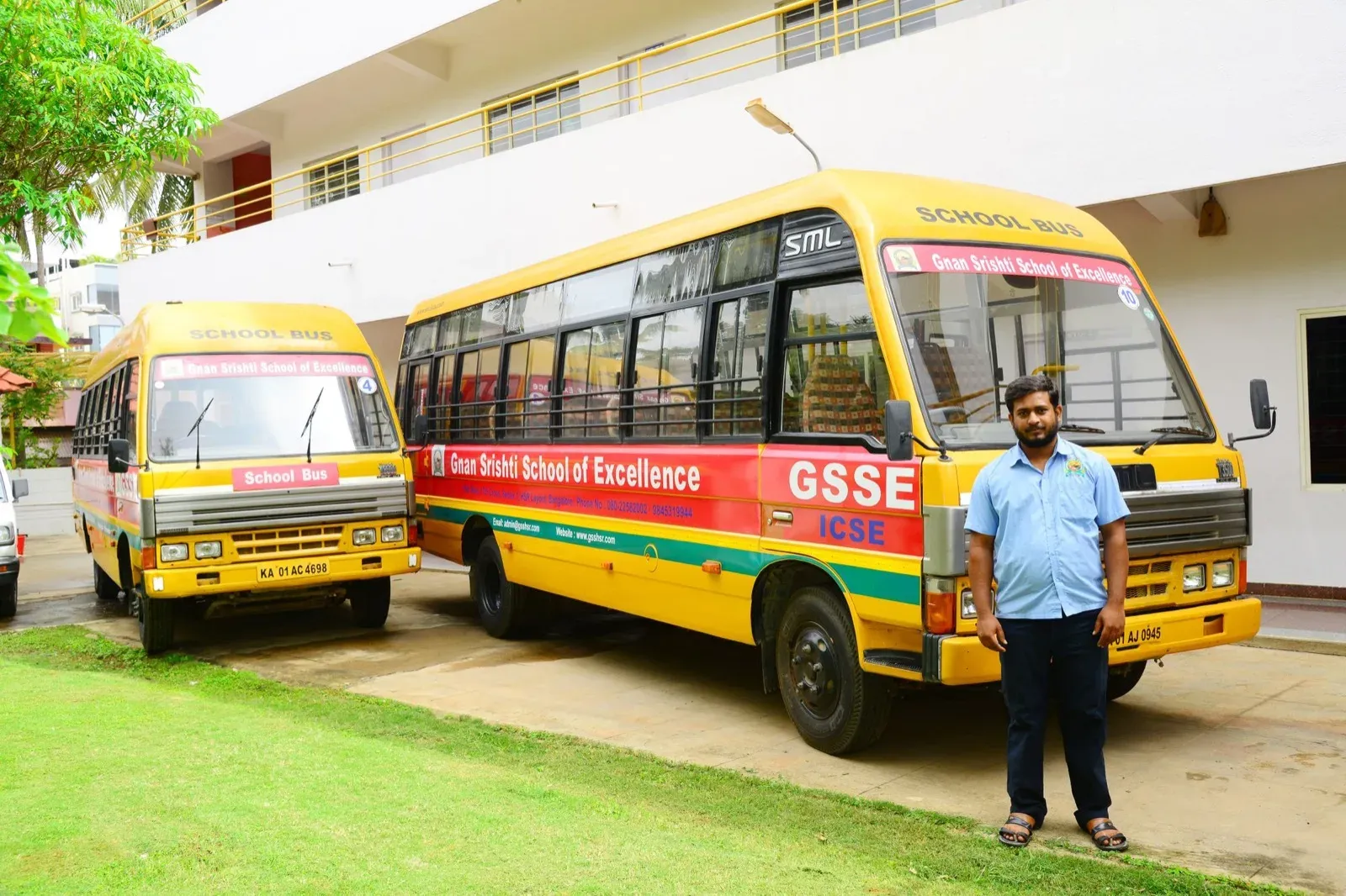 Two Gnan Srishti school buses parked outside the school building