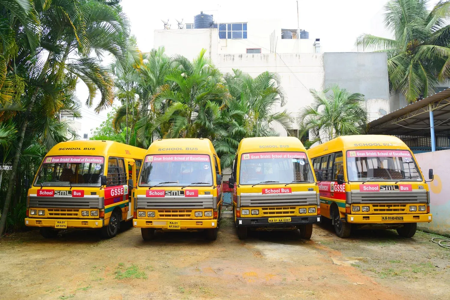Four Gnan Srishti school buses parked in a row